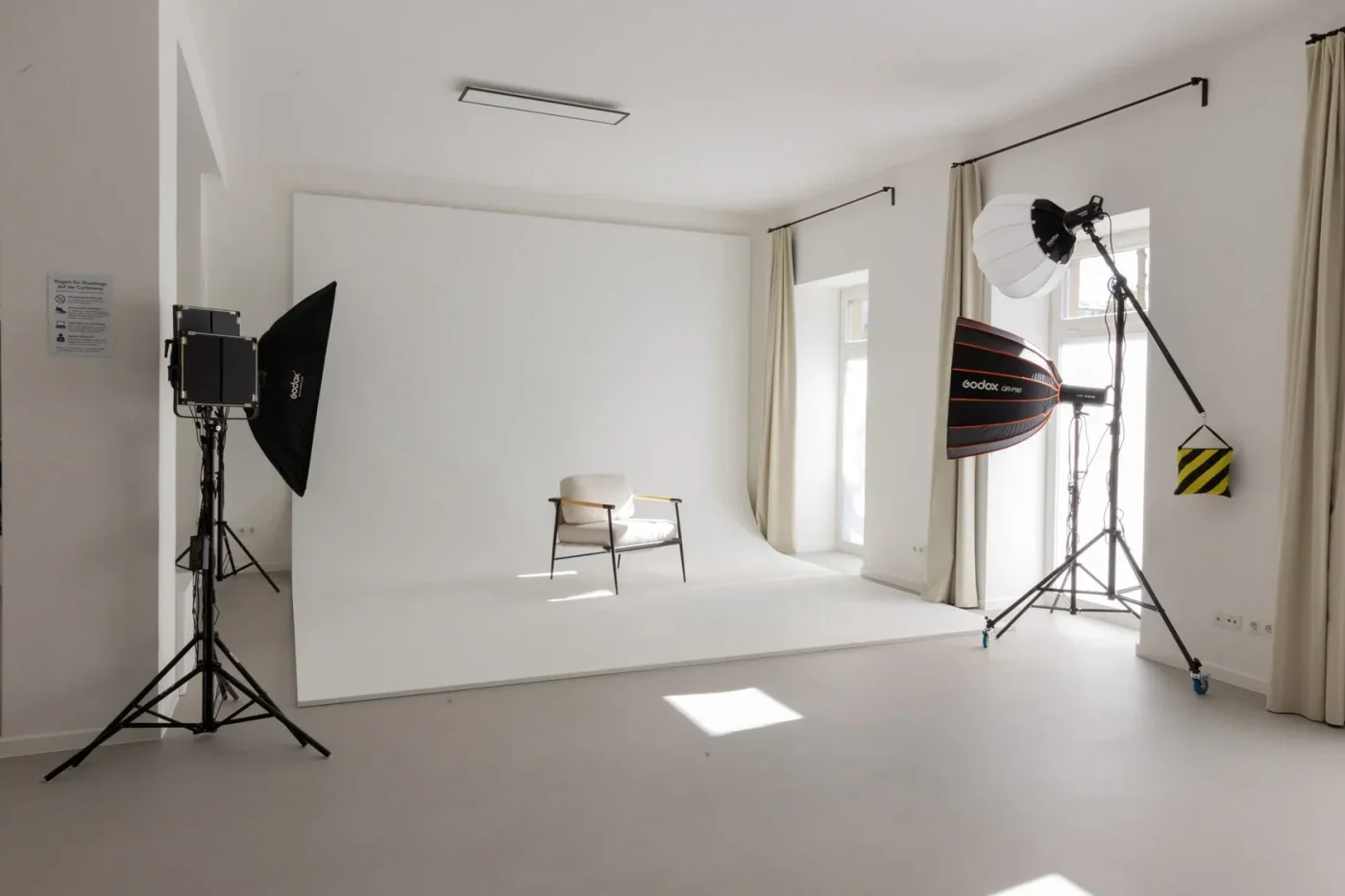 Minimalistisches Fotostudio mit weißem Cyclorama-Hintergrund und Sessel