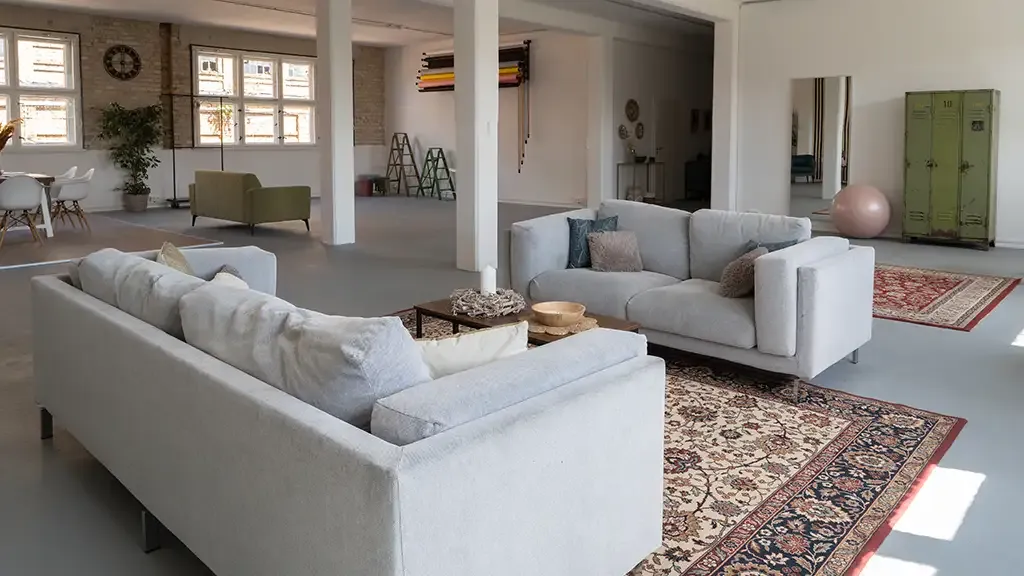 Industrieller Loft-Loungebereich mit Sofas, Perserteppichen und Ziegelwänden