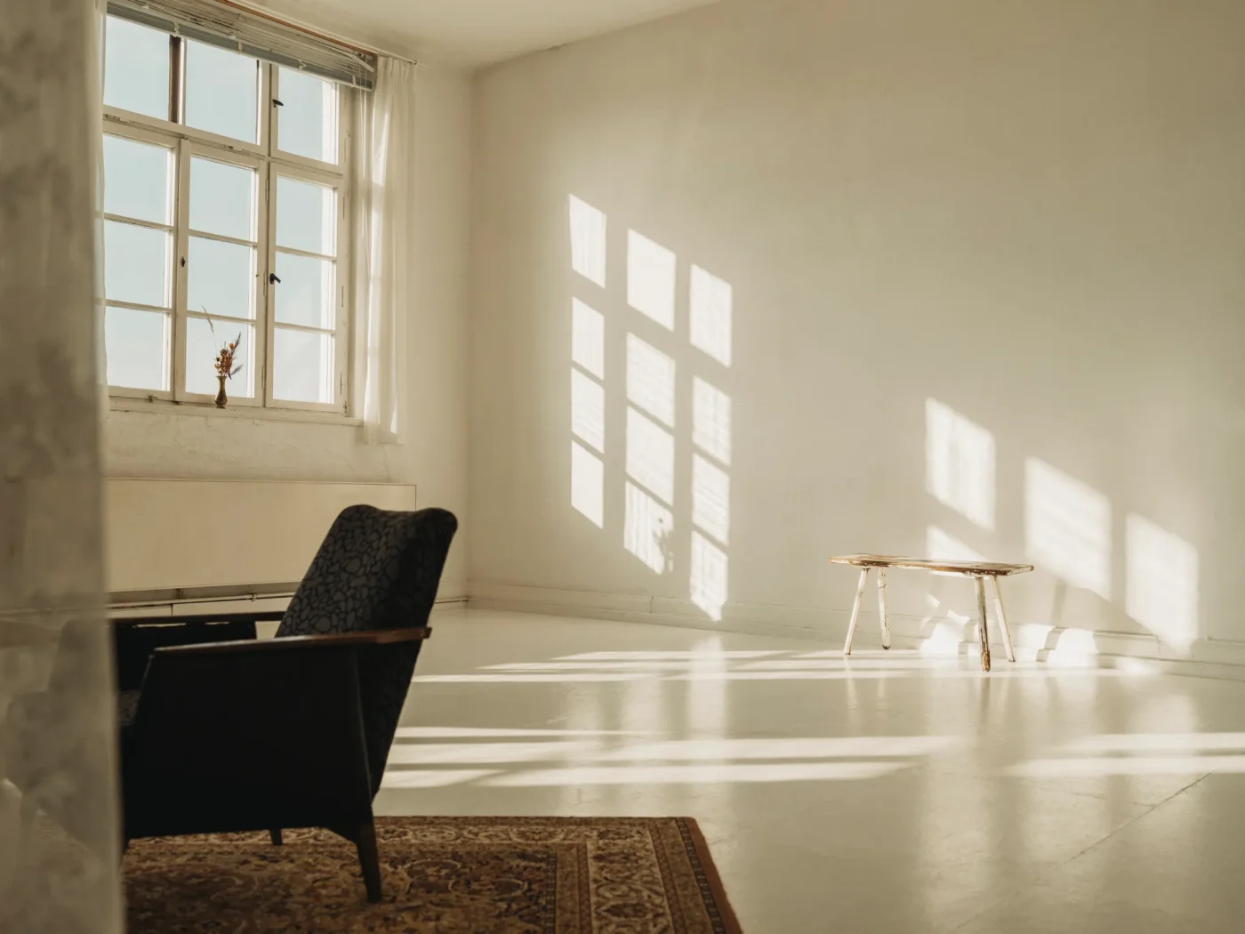 Lichtdurchflutetes Loft-Studio mit Vintage-Sessel im warmen Fensterlicht